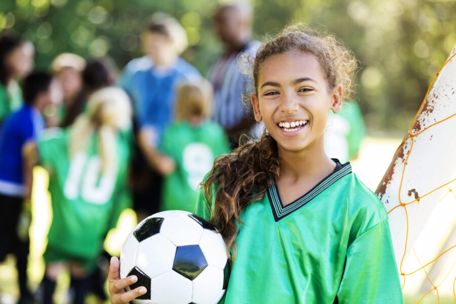 Happy girl smiles after winning soccer game